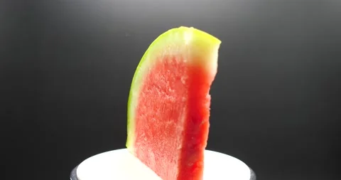 Watermelon slice rotating on its side isolated on black representing fresh fruit Video stock 205330290