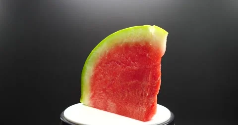 Watermelon slice turning slowly isolated on black fresh Stock Footage 205330777