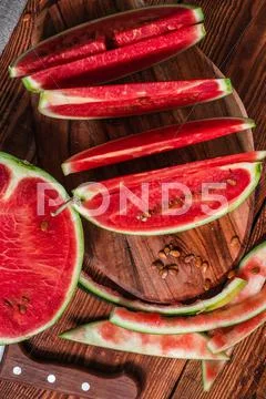 Watermelon slices and peels lying on the board Stock Photos