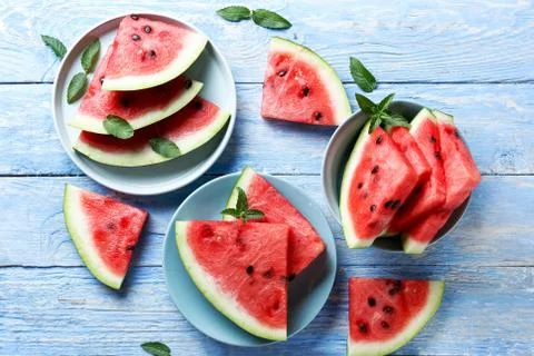 Watermelon slices with mint on a blue rustic wood background. Summertime conc Stock Photos