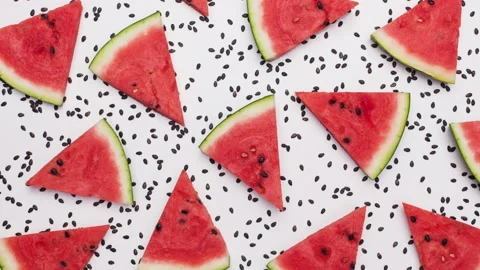 Watermelon slices on white surface with melon seeds flowing Stock Footage 131927639