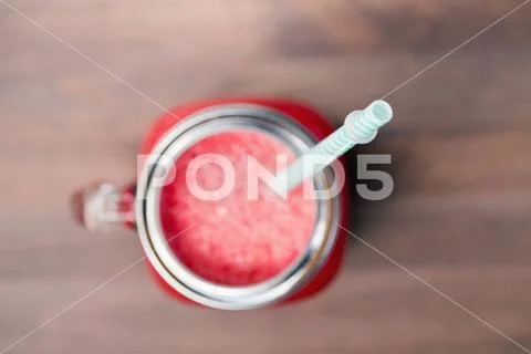 Watermelon smoothie in a mason jar. Shallow DOF focus on a tube Stock Photos