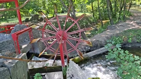 Watermill Wheel Turning Over a Fast Flowing Stream in a Peaceful Forest Stock Footage 345199265