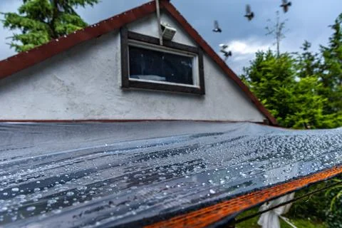 Waterproof plastic cover stretched over garden terrace during heavy rain Stock Photos