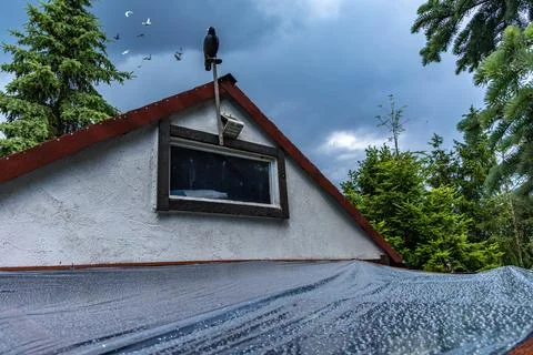 Waterproof plastic cover stretched over garden terrace during heavy rain Stock Photos