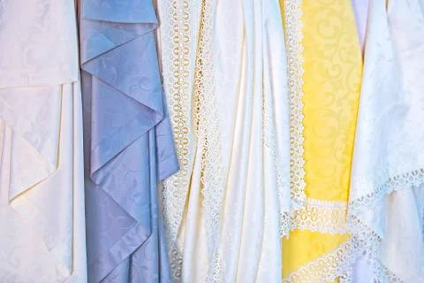 Waterproof silk tablecloths in the store. Openwork fine beautiful fabrics, te Stock Photos