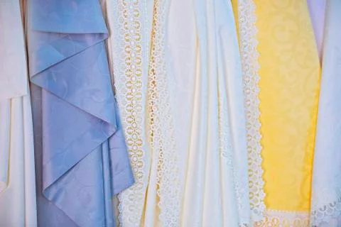 Waterproof silk tablecloths in the store. Openwork fine beautiful fabrics, te Stock Photos