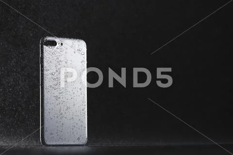 Waterproof smartphone covered with water Stock Photos
