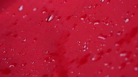 Waterproof textile cloth concept. Rain, water drops are splashing on coat but Stock Footage 176360714