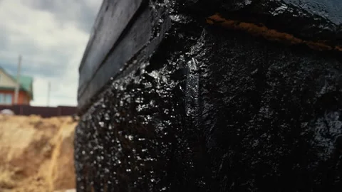 Waterproofing concrete foundation with black bitumen mastic Stock Footage 341294697