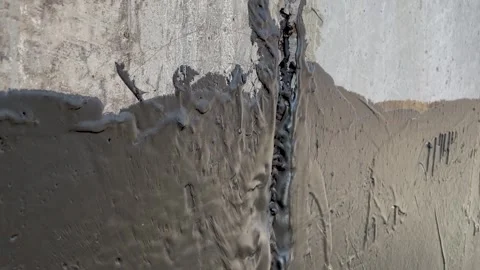 Waterproofing a concrete wall with liquid bitumen Stock Footage 249208543