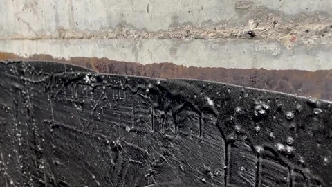 Waterproofing a concrete wall with liquid bitumen Stock Footage 272967427