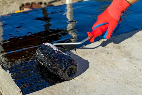 Waterproofing of the Foundation with a bituminous primer. Close up view. Shallow Foto stock