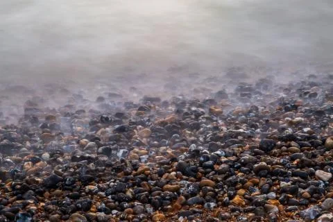 The water's edge and pebble beach, taken with a long exposure Stock Photos