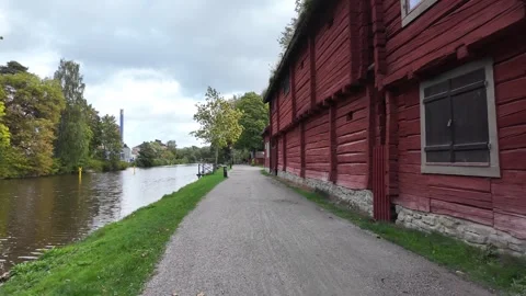 Waterside Path beside Red Timber Building and Canal in Sweden Stock Footage 347682796