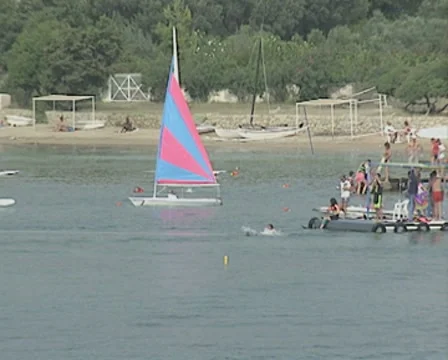 Waterskier starts from a jetty and is towed past multiple small boats Stock Footage