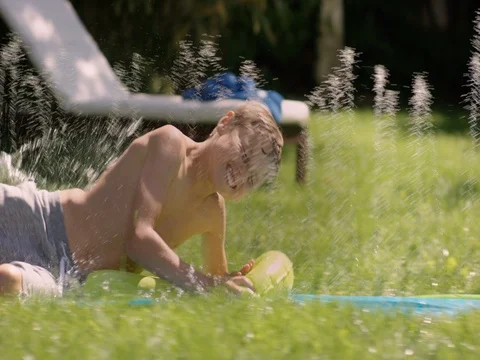 Waterslide fun in the graden. Young Boy is sliding with full speed Stock Footage 78044766