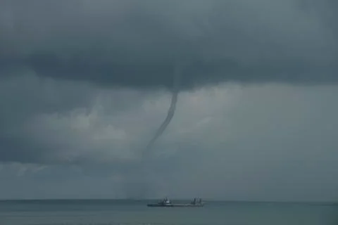 Waterspout or tornado forms off shore from beach A Stock Photos