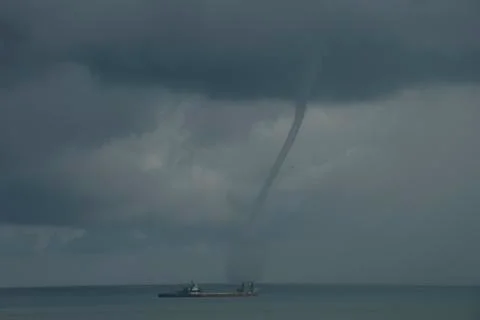 Waterspout or tornado forms off shore from beach D Stock Photos