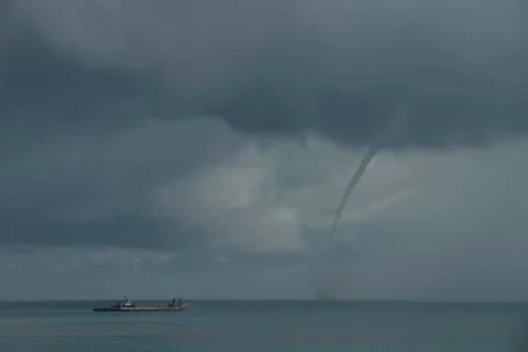 Waterspout or tornado forms off shore from beach E Stock Photos