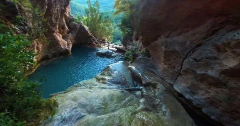 Waterstream Goes Inside Turquoise Pool and Waterfall to the Forest Stock Footage 130570445
