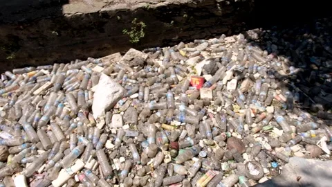 Waterway canal full of floating plastic bottles and trash stopped from ocean in Stock Footage 337963603