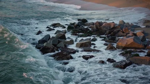 Wave approaching on the rocks and exploding hard on them Stock Footage 134703850
