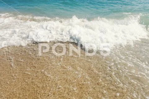 Wave of blue ocean on sandy beach close up Summer Background Stock Photos