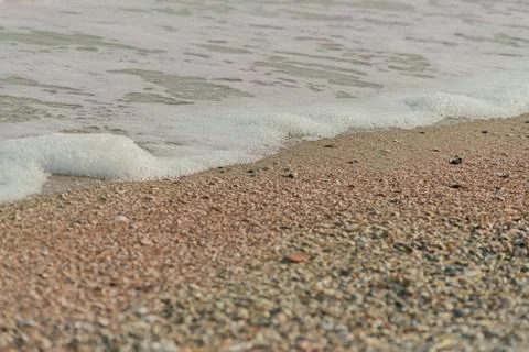 Wave of blue ocean on sandy beach. texture Background. Stock Photos