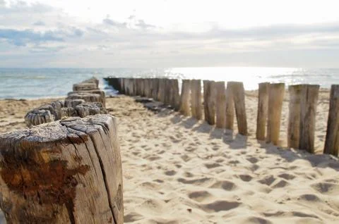 Wave breakers at the beach with clouds Stock Photos