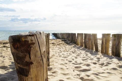 Wave breakers at the beach with clouds Stock Photos