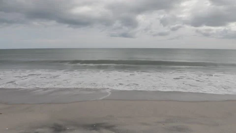 Wave breaking on the beach in slow motion, ocean and cloudy gray sky. Stock Footage 182441964