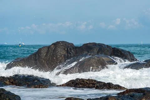 Wave Breaking on Dark Rocks Stock Photos