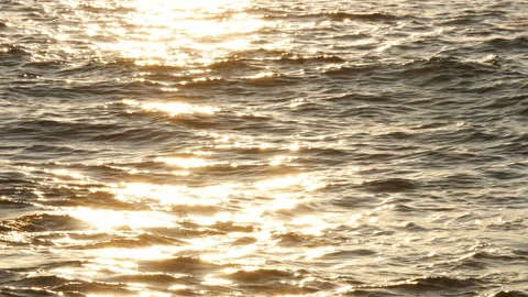 Wave breaking on ocean closeup at sunset with orange reflections on water Stock Footage 111402203