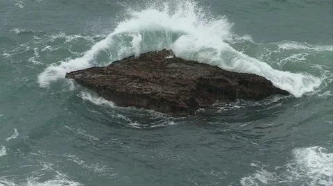 Wave breaking over  black rock Stock Footage 11138220