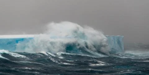 Wave breaking over huge tabular iceberg Stock Photos
