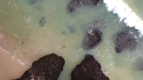 Wave breaking into the rocks and the sandy beach in Bali, Indonesia Stock Footage 80046969