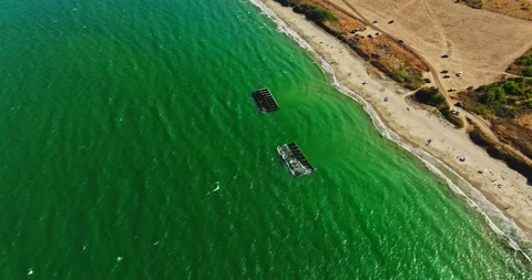 Wave Breaking Structures On A Picturesque Vibrant Beach Summer Vacation Aerial Video stock 300445315
