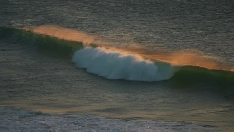 Wave breaking at sunrise orange light Stock Footage 261705282