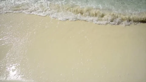 A wave breaking on a white sand beach Stock Footage 146972029