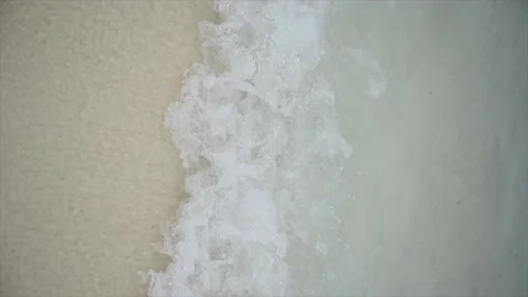 A wave breaking on a white sand beach Stock Footage 146972164