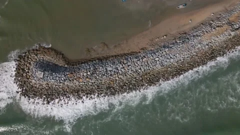 Wave breaks after hitting wave breaker on the ocean Stock Footage 169587672