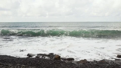 Wave breaks against the rocks slow mo Video stock 82906383