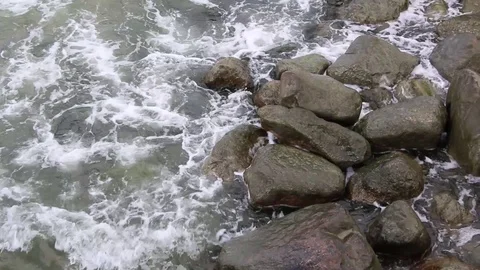 A wave breaks on a large rock in the middle of a rough sea. Spectacular view of  Stock Footage 118816238