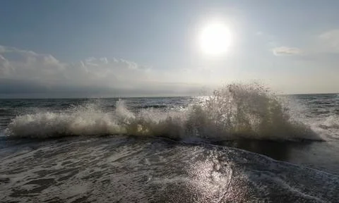 The wave breaks on the pier against the background of the rising sun, rest on a Stock Photos