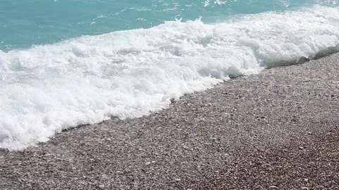Wave breaks slow motion on a pebble beach Video stock 153834026
