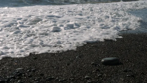 Wave covers a stone Stockbeeldmateriaal 130083443