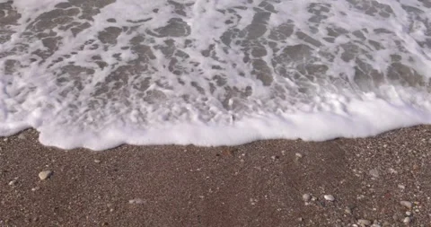 A wave crashes onto a sandy shore. View from the top Stock Footage 258577802