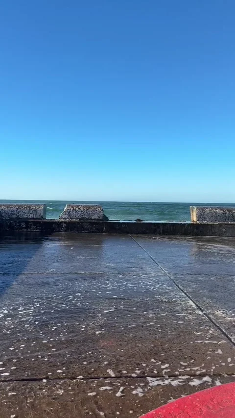 Wave crashing up against the harbor wall  Stock Footage 334026529