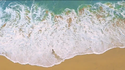 A wave crashing onto a beach, captured from a drone in 4K. Stock Footage 273141356